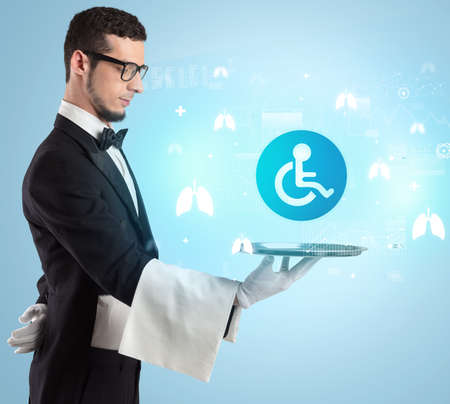 Handsome young waiter in tuxedo holding healthcare icons on tray
