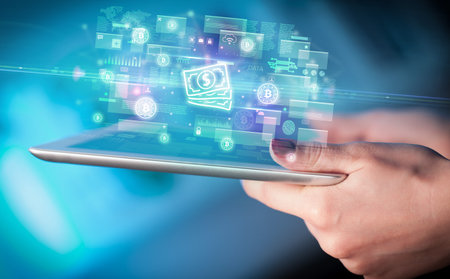Close-up of a hand using tablet, currency conceptの写真素材