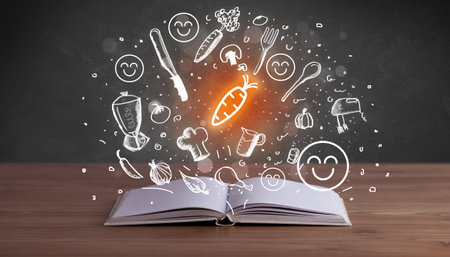 Open recipe book with food related icons aboveの写真素材