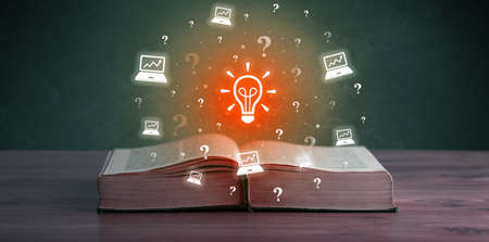 Open book with business icons aboveの写真素材