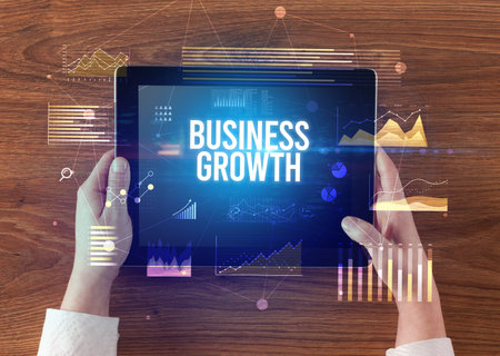 Close-up of hands holding tablet with business inscription