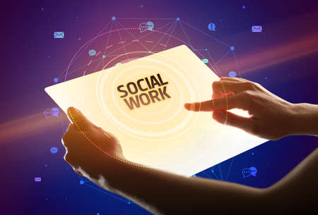 Holding futuristic tablet with SOCIAL WORK inscription, social media conceptの写真素材