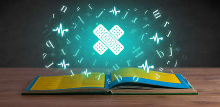 Open medical book with health icons aboveの写真素材