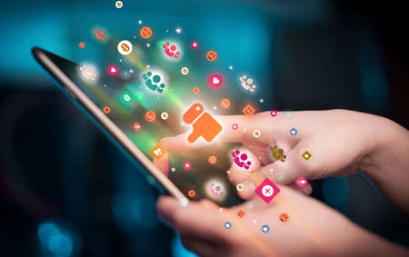 Close-up of a hand using tablet with social media icons