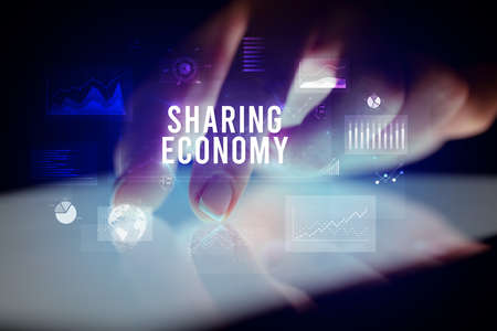 Finger touching tablet with business graphs and icons conceptの写真素材