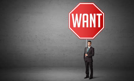 Young business person holding road signの写真素材