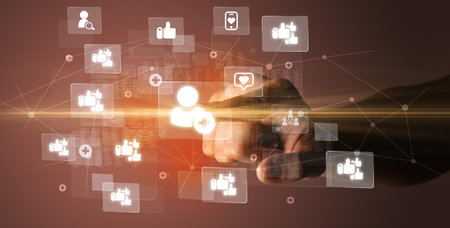 Hand pressing social media multimedia application screen with media icons on futuristic conceptの写真素材