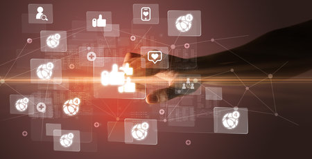 Hand pressing social media multimedia application screen with media icons on futuristic conceptの写真素材