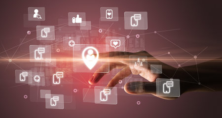 Hand pressing social media multimedia application screen with media icons on futuristic conceptの写真素材