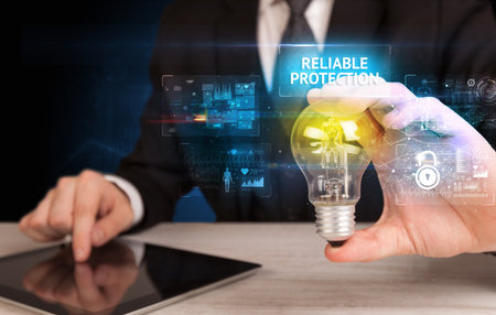 Businessman holding a light bulb, online security conceptの写真素材