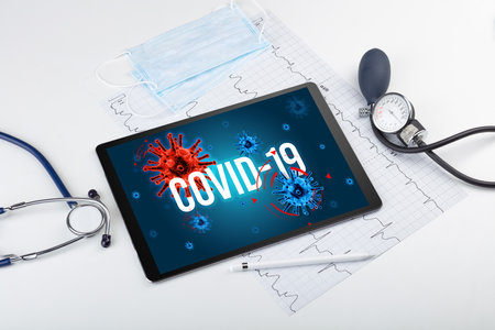Tablet pc and doctor tools on white surfaceの写真素材