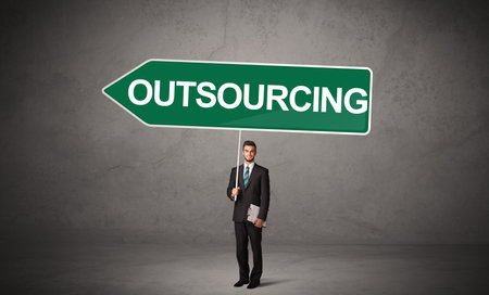 Young business person in casual holding road signの写真素材