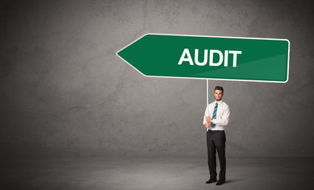 Young business person in casual holding road signの写真素材