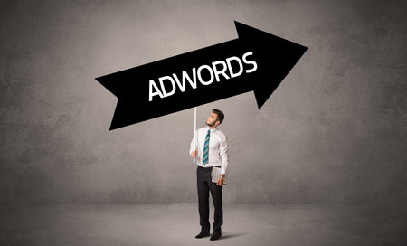 Young business person in casual holding road signの写真素材