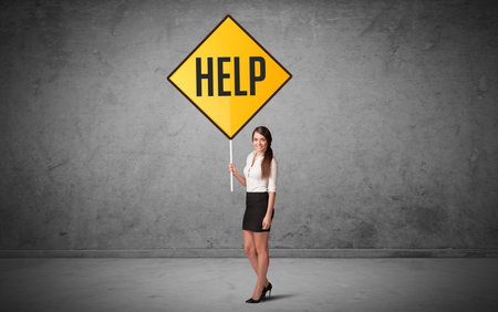 Young business person holding road signの写真素材