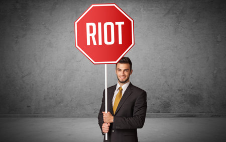 Young business person holding road signの写真素材