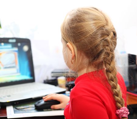A girl with gold earrings playing computer games.