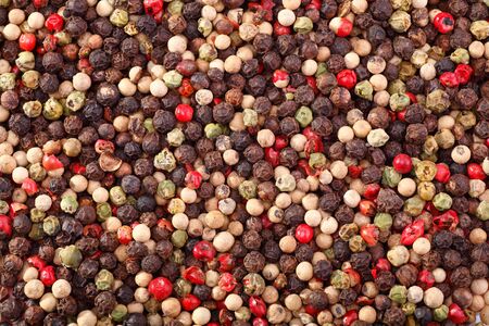 Spices closeup. The background of black, white, green and pink Peppercorns.