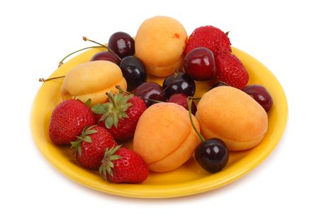 Fruits on the yellow plate. Isolated object on a white backgroundの写真素材