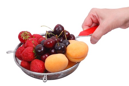 Fresh strawberries, apricot and cherry in a colander washed in water. Isolated on white backgroundの写真素材