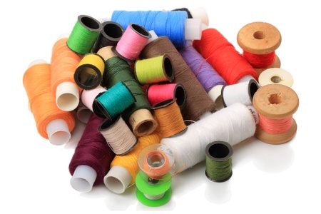 Heap spools of sewing threads isolated on a white background