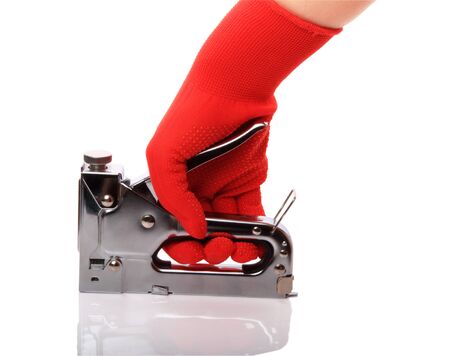 Building a stapler in his hand in the red gloves isolated on white backgroundの写真素材