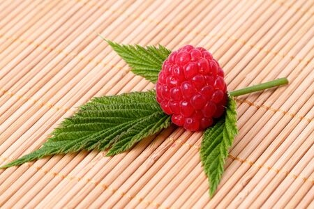 Ripe raspberry on green leaf