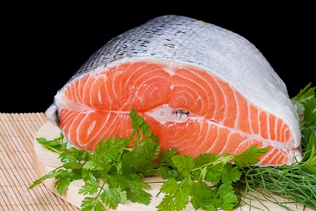 Piece of fatty red fresh trout on a black backgroundの写真素材