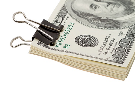 A stack of dollar strengthened by a large paper clip. Isolated on white backgroundの写真素材