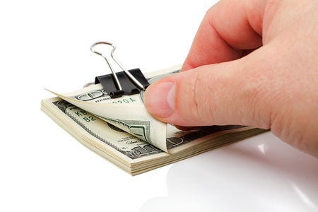 Counting a stack of dollars held together by a large paper clip. Isolated on white backgroundの写真素材