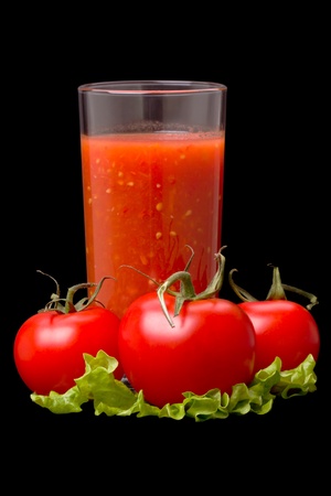 Tomato juice and tomatoes on a salad isolated on black backgroundの写真素材