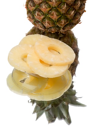 Slices pineapple on a plate and the reflection of a ripe pineapple. Isolated on white backgroundの写真素材