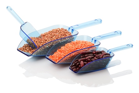Plastic scoops with buckwheat, lentils and beans isolated on white backgroundの写真素材