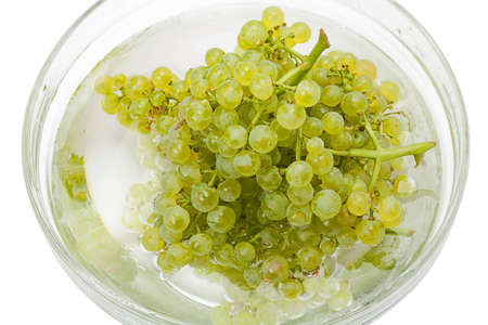 Seedless grapes transparent bowl with water on a white backgroundの写真素材