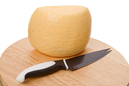 Knife for slicing cheese and cheese on a cutting board. Isolated on white backgroundの写真素材