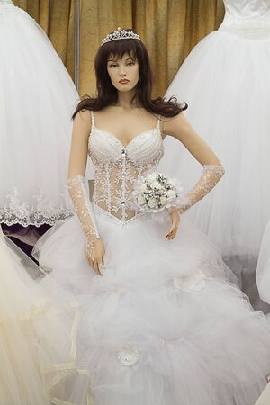 Female mannequin in a wedding dress with a diadem and a bouquet of flowersの写真素材