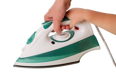 Women's and children's hand holding an electric iron. Isolated on white background
の写真素材