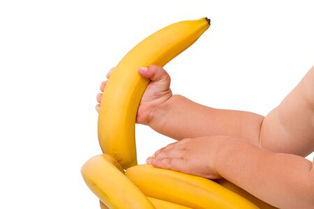 Child pulls a banana isolated on white backgroundの写真素材