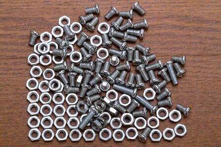 Small nuts and bolts on the brown table