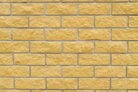 Brick wall of yellow natural stone background and textureの写真素材