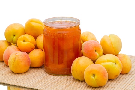 Heap apricots and a glass jar with apricot jamの写真素材