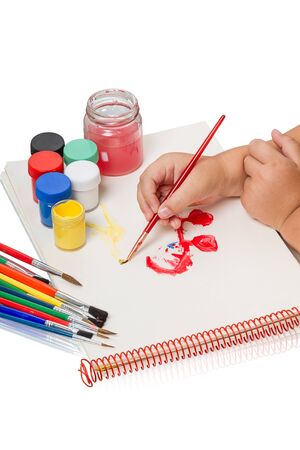 Child draws brush watercolor. Isolated on white backgroundの写真素材
