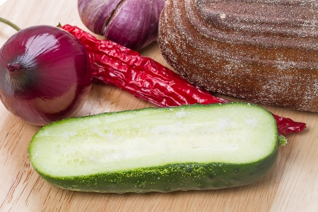 Half of cucumber with salt, rye bread, onion, garlic and pepperの写真素材