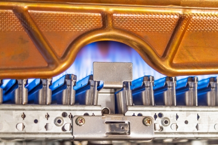 Blue flames of a gas burner inside of a boilerの写真素材
