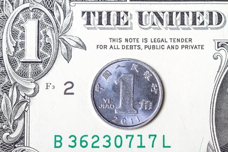 Chinese Yuan coin in paper U.S. dollarの写真素材