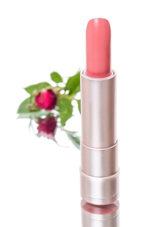 Lipstick and a red rose isolated on white backgroundの写真素材