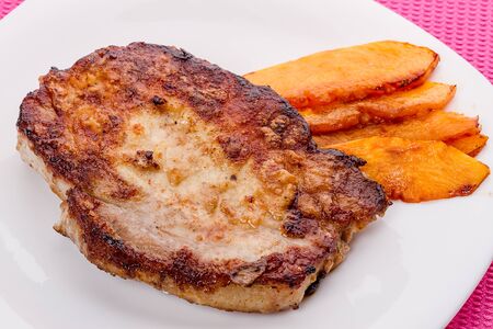Roast pork with pumpkin on a white plateの写真素材