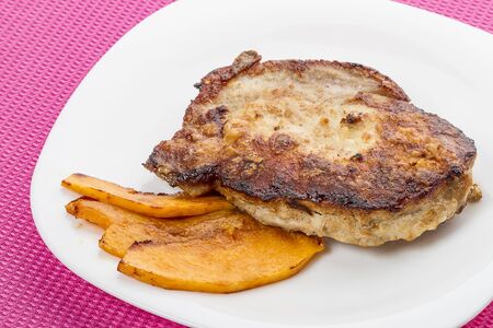 Roast pork with pumpkin on a white plateの写真素材