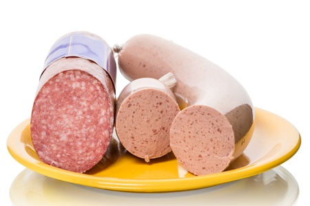 Stick of salami and lliverwurst on a yellow plate isolated on white backgroundの写真素材