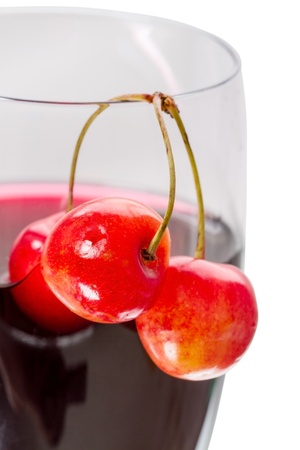 Three cherries and a glass of cherry juice close-upの写真素材